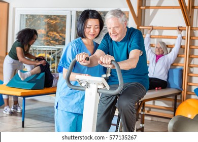 Asian nurse helping elder man in hospital gym. - Powered by Shutterstock