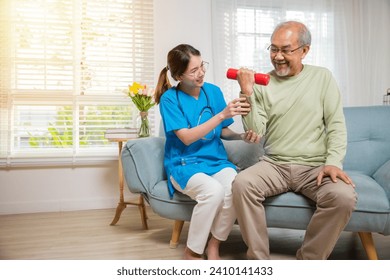 Asian nurse physiotherapist helping senior man in lifting dumbell at retirement home, Young nurse take care support training elderly sitting on sofa using dumbbell workout exercise, Healthcare medical - Powered by Shutterstock