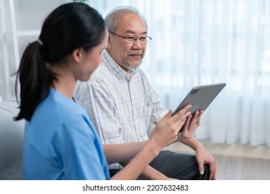 Asian Nurse Showing Health Checkup Report To Grandfather And Giving Advice. Medical Assisted Living Visit Senior Patient At Home. Home Nursing And Healthcare Caregiver Concept