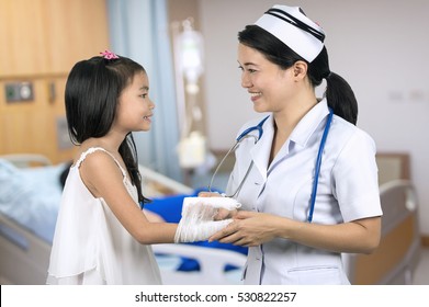 Asian Nurse In Uniform Pediatric Care Girls With Background Blur Patient Room.