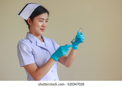 Asian Nurse Wearing Blue Glove Preparing Medicine For Injection.