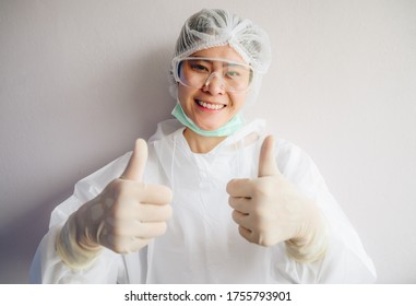 Asian Nurse Wearing PPE Suit And Showing Thumbs Up. In Coronavirus Pandemic Outbreak We Should Support And Encourage Healthcare Worker By Stay Home And Listen To Medical Advice.