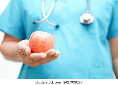 Asian Nutritionist holding apple healthy food for patient in hospital, nutrition and vitamin.