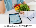 Asian nutritionist using tablet to explaining personalized meal plan with AI to patient during healthcare consultation, healthy lifestyle, woman dietitian showing nutrition plan with AI on tablet.