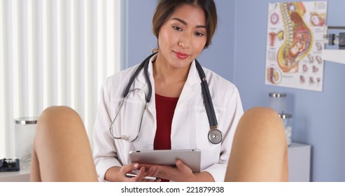 Asian OBGYN talking to patient in exam room