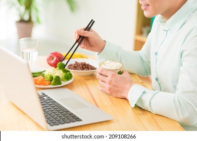 Asian Office Worker Having Lunch In Front Of Laptop