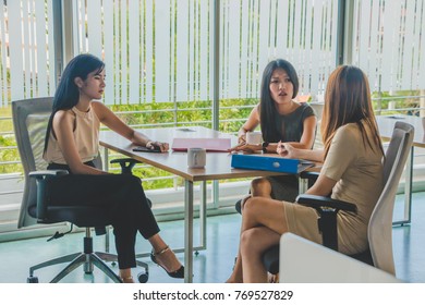 Asian office worker sitting in a relaxed meeting at work.
