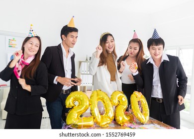 asian officer team celebrate in new years party, they feeling cheer and happy, they stand and dance in office, happy new years 2020
