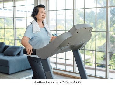 Asian old chubby retirement pensioner happy healthy female sport fitness woman in casual sportswear walking running on machine treadmill in gym. - Powered by Shutterstock