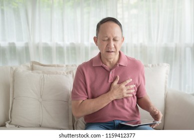 Asian old man with chest pain suffering from heart attack in home