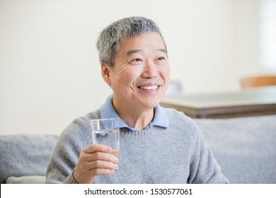 Asian Old Man Drink Water And Feel Good At Home