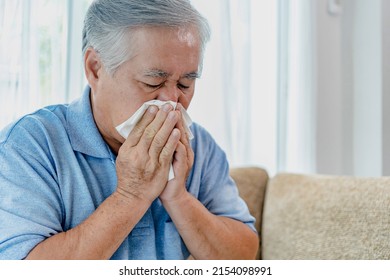 Asian Old Man Feeling Sick With Cold And Fever At Home, Ill With Flu Disease Sitting On The Sofa