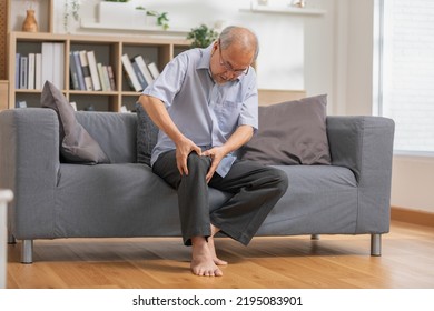 Asian old man with his knee joint pain in sofa, pain in the elderly, health care, elderly care. Elderly man having a knee pain and sitting down. Grandfather with knee pain. - Shutterstock ID 2195083901