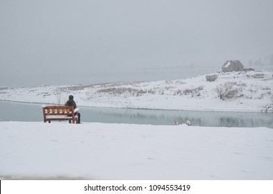 An Asian Old Man Sitting On The Bench Facing The Good Shepherd Catholic Church, New Zealand.