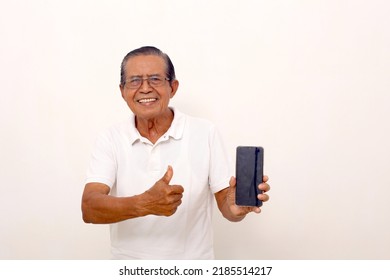 Asian Old Man Standing While Holding A Cell Phone And Showing Thumbs Up. Isolated On White