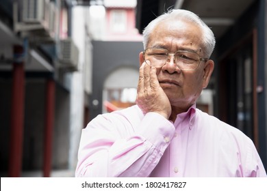 Asian old senior man suffering from toothache, tooth decay, tooth sensitivity, teeth grinding problem; oral health care concept