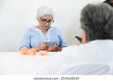 Asian old senior woman knitting getting diagnosed, examined by a doctor, healthcare service in a retirement nursing home facility outdoor park. - Powered by Shutterstock