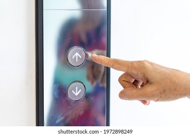 Asian Old Woman Hand Points To The Button Of Elevator.