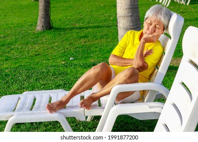 Asian Old Woman Take A Rest Lay On Chair At Beach. Senior Retirement Travel On Summer Vacation With Happy.