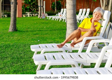 Asian Old Woman Take A Rest Lay On Chair At Beach. Senior Retirement Travel On Summer Vacation With Happy.