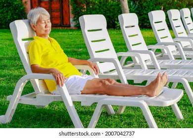 Asian Old Woman Take A Rest Lay On Chair At Beach. Senior Retirement Travel On Summer Vacation With Happy.