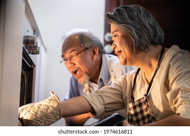 Asian older grandparents making pizza at home. Senior woman open the oven and bring the foods out from machine. Elder man looking at meal and smell it with smile face, enjoy famiy activity together. - Powered by Shutterstock