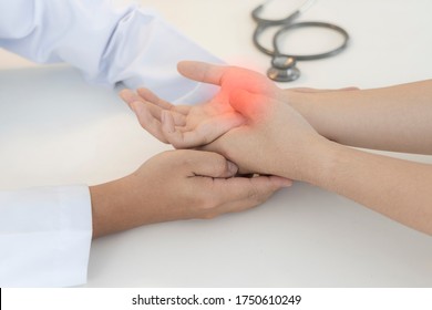 Asian Orthopaedic Doctor Doing Physical Examination In The Patient With Wrist Pain And Numbness At The Clinic. Pain From Tendinitis And Sport Injury Or Repetitive Use Of Computer. Medical Concept.