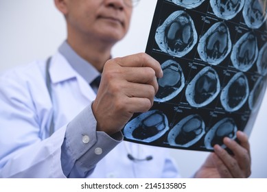 Asian Orthopedics Surgeon Doctor Examining Patient's Knee Joint X-ray Films, MRI Bone, CT Scan In At Radiology Orthopedic Unit In Hospital. Knee Joint Film X Ray, Close Up