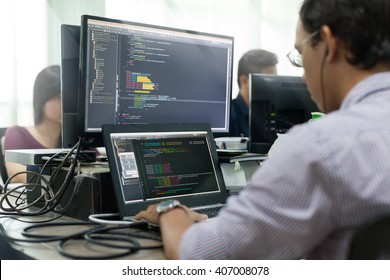 Asian Outsource Developer Looking Screen Sitting At Desk Working Laptop Computer Mobile Application Software Real Office