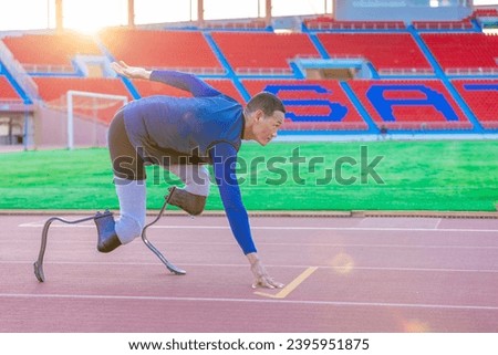 Asian para-athlete with prosthetic blades leg in stadium practicing workout for running competition. Amputee sports man runner practicing running workout. Disabled athlete man sport concept.