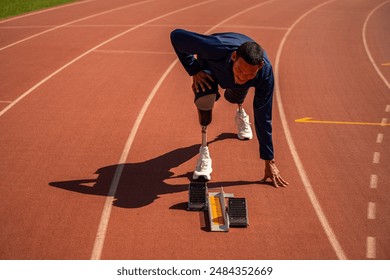 Asian para-athlete relaxes and Warm-up runner prosthetic leg on the track alone outside on a stadium track Paralympic running concept. - Powered by Shutterstock