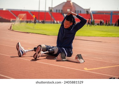 Asian para-athlete runner prosthetic leg on the track training alone outside on a stadium track Paralympic running concept. - Powered by Shutterstock