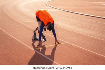 Asian para-athlete runner prosthetic leg on the track alone outside on a stadium track Paralympic running concept. - Powered by Shutterstock