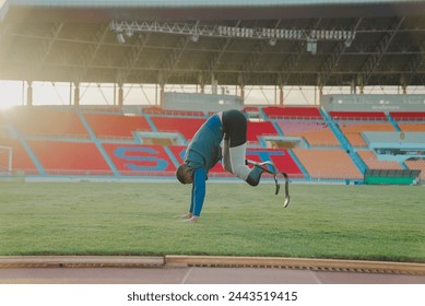 Asian para-athlete runner prosthetic leg on the track training alone outside on a stadium track Paralympic running concept. - Powered by Shutterstock