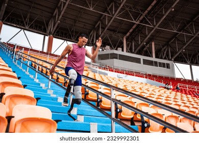 Asian para-athletes disabled with prosthetic blades running at stadium. Attractive amputee male runner exercise and practicing workout for Paralympics competition regardless of physical limitations