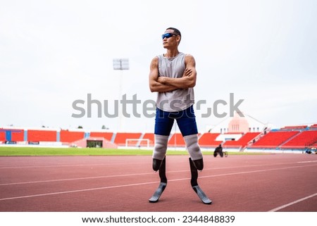 Asian para-athletes disabled with prosthetic blades standing at stadium. Attractive amputee male runner exercise and practicing workout for Paralympics competition regardless of physical limitations.