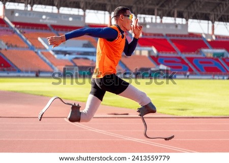 Asian para-athletes with prosthetic blades sprint on a running track at stadium.