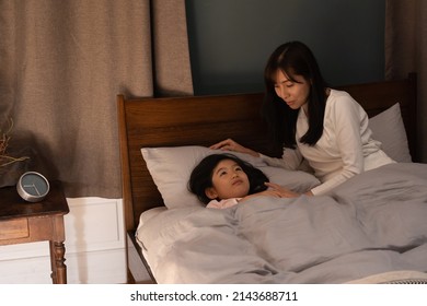 Asian Parent And Child Sleeping In Bed