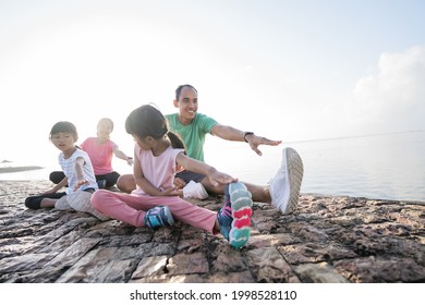 Asian Parent And Children Do Sport Outdoor. Healthy Family Stretching And Exercise In The Morning