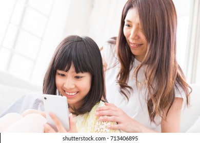  Asian Parent And Daughter,smart Phone