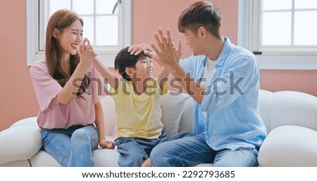 asian parent happy with kid growing up - father mother son sitting on the sofa with high five gesture so much fun such a good family interaction relationship