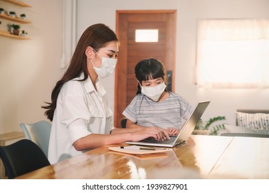 Asian Parent Mother Working At Home With Daughter Study Online Class Wearing Protective Surgical Face Mask From Coronavirus Covid-19 Pandemic Family Lifestyle, Laptop Technology Video Call Conference