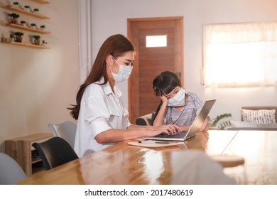 Asian Parent Mother Working At Home With Daughter Study Online Class Wearing Protective Surgical Face Mask From Coronavirus Covid-19 Pandemic Family Lifestyle, Laptop Technology Video Call Conference