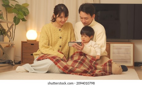 Asian Parents And Children Who Enjoy Watching Mobile Phones