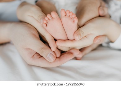 Asian Parents Hands Holding One Month Old Baby Feet. Close Up Parents' Hand Holding Their Baby. Love Family Healthcare And Medical Body Part. Loving Happy Family Concept. Parents Out Of Focus.