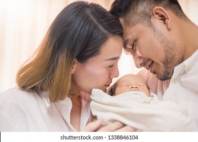 Asian Parents With Newborn Baby, Close Up Portrait Of Asian Young Couple Father Mother Holding Kissing New Born Baby In Hospital Bed. Happy Family Love Newborn Nursery Mother’s Day Holiday Concept