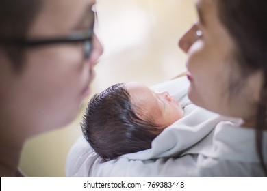 Asian Parents With Newborn Baby, Close Up Portrait Of Asian Young Couple Holding Their New Born Baby.