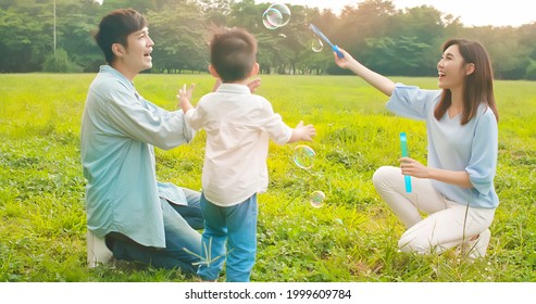 Asian Parents Play Bubbles With Kid Outdoor Happily