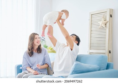 Asian Parents Playing With Their Baby At Home