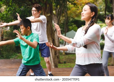 Asian parents, son and daughter exercising outdoors, practicing tai chi. family fitness time in garden. - Powered by Shutterstock